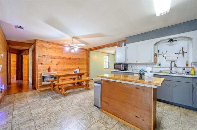 431 Canoe Rd, Broken Bow, OK 74728 - kitchen featuring wood walls, a sink, ceiling fan, light countertops, and black microwave