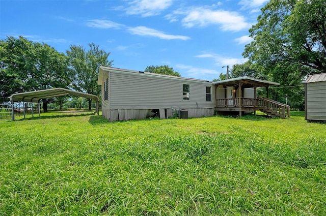 2991 Peavey Xing, Broken Bow, OK 74728 - rear view of property featuring a detached carport, a lawn, central AC, and a wooden deck
