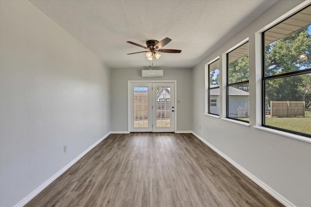 2901 Pine Ave, Oklahoma City, OK 73126 - empty room featuring wood finished floors, ceiling fan, an AC wall unit, and a textured ceiling
