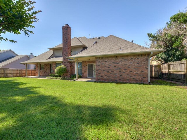 3713 Barwick Ct, Norman, OK 73072 - rear view of house with a chimney, a shingled roof, brick siding, and a patio area