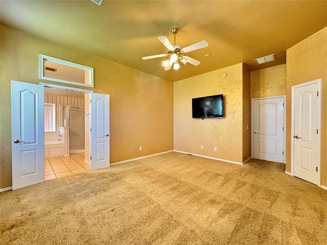 4409 Whitmere Ct, Norman, OK 73072 - unfurnished bedroom featuring carpet flooring, tile patterned flooring, ensuite bathroom, a textured wall, and a ceiling fan