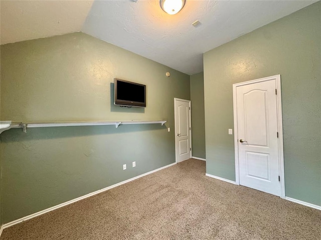 4409 Whitmere Ct, Norman, OK 73072 - unfurnished bedroom with vaulted ceiling, carpet floors, and a textured wall
