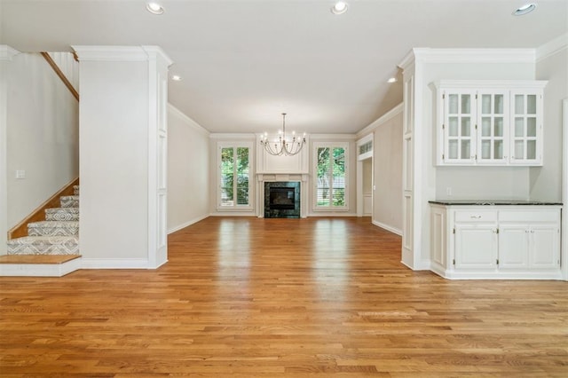 4609 Summerfield Ct, Norman, OK 73072 - unfurnished living room featuring crown molding, a chandelier, stairs, light wood finished floors, and recessed lighting