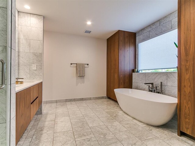 4107 Northhampton Dr, Norman, OK 73072 - full bath featuring a soaking tub, vanity, marble look tile flooring, and recessed lighting