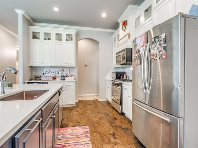 17217 Prado Dr, Oklahoma City, OK 73170 - kitchen featuring stainless steel appliances, a sink, ornamental molding, light countertops, and white cabinetry