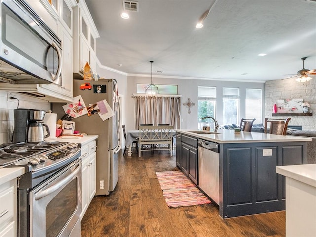 17217 Prado Dr, Oklahoma City, OK 73170 - kitchen featuring appliances with stainless steel finishes, light countertops, white cabinetry, a chandelier, and crown molding