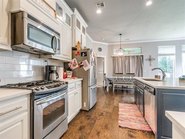 17217 Prado Dr, Oklahoma City, OK 73170 - kitchen with stainless steel appliances, a sink, light countertops, crown molding, and tasteful backsplash