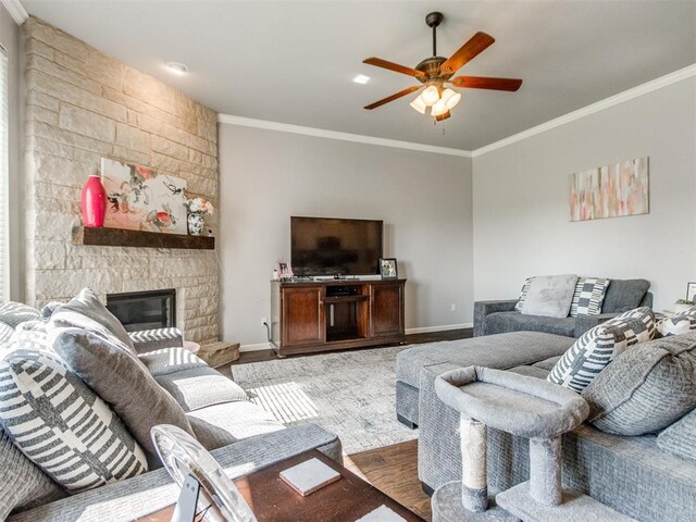 17217 Prado Dr, Oklahoma City, OK 73170 - living room with ornamental molding, a ceiling fan, baseboards, a stone fireplace, and wood finished floors
