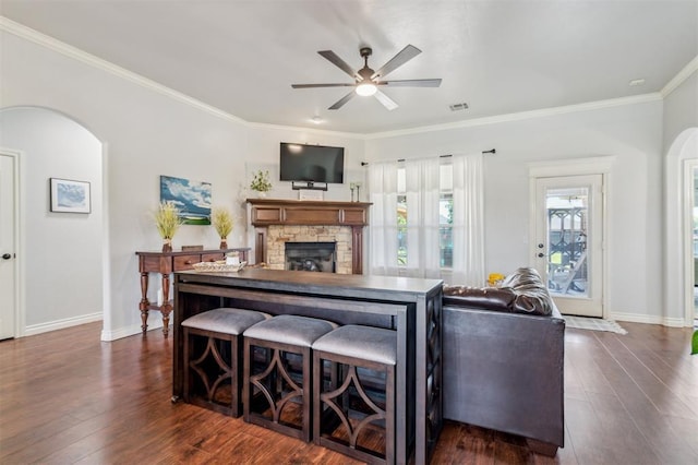 908 Carol Ann Pl, Moore, OK 73160 - living room with arched walkways, a ceiling fan, dark wood-style floors, and ornamental molding