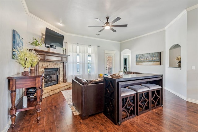 908 Carol Ann Pl, Moore, OK 73160 - living room with ceiling fan, a fireplace, wood finished floors, arched walkways, and crown molding