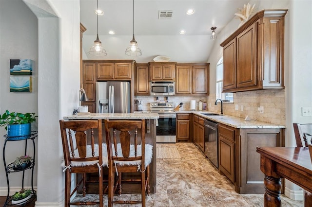 908 Carol Ann Pl, Moore, OK 73160 - kitchen with appliances with stainless steel finishes, backsplash, light stone counters, brown cabinetry, and recessed lighting