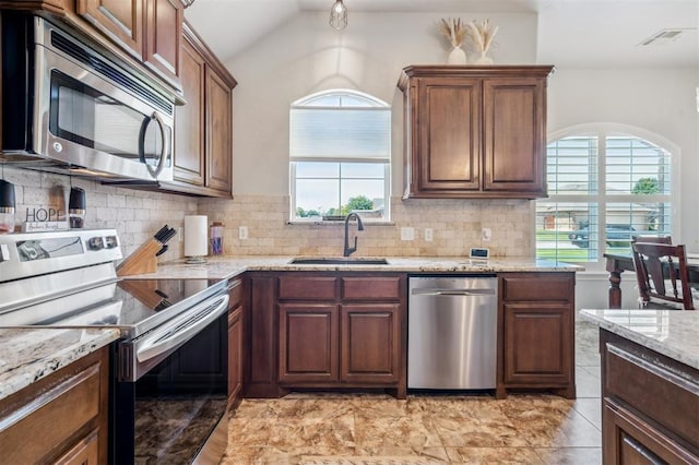 908 Carol Ann Pl, Moore, OK 73160 - kitchen with stainless steel appliances, healthy amount of natural light, tasteful backsplash, and vaulted ceiling