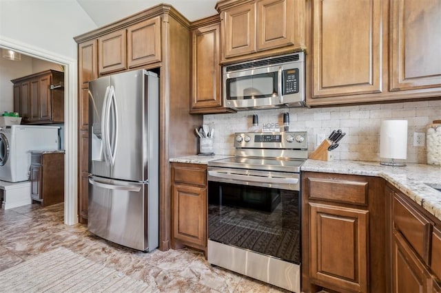 908 Carol Ann Pl, Moore, OK 73160 - kitchen with appliances with stainless steel finishes, decorative backsplash, brown cabinets, and light stone countertops