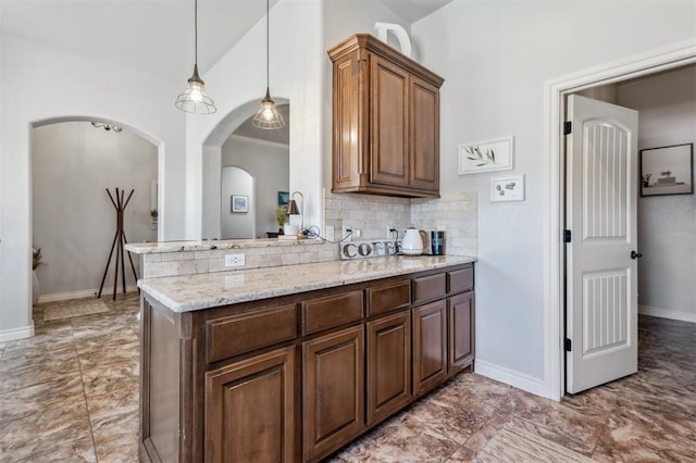 908 Carol Ann Pl, Moore, OK 73160 - kitchen with tasteful backsplash, marble look tile flooring, light stone countertops, and arched walkways
