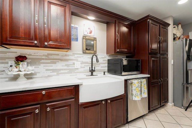 5108 NW 19th Ter, Oklahoma City, OK 73127 - kitchen featuring stainless steel appliances, a sink, light tile patterned floors, decorative backsplash, and light countertops