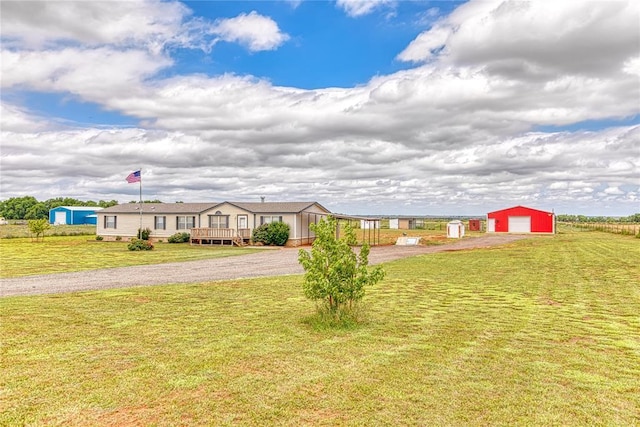 20649 E 1110th Rd, Canute, OK 73626 - view of front of property featuring an outbuilding, a wooden deck, a front yard, and a detached garage