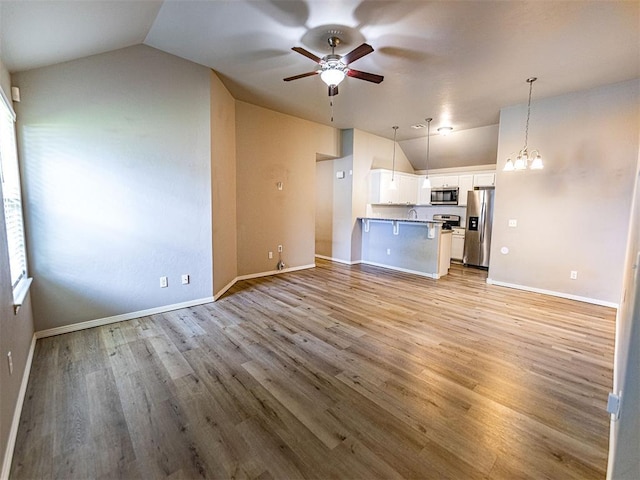 4212 Bonaparte Blvd, Midwest City, OK 73110 - unfurnished living room with vaulted ceiling, a ceiling fan, light wood finished floors, a chandelier, and baseboards
