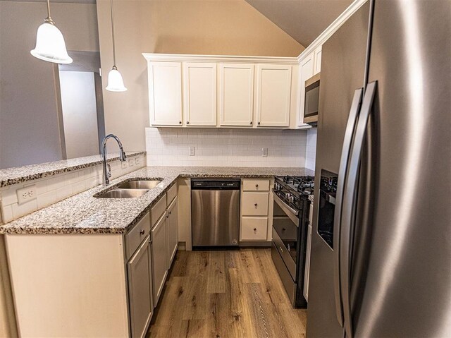 4212 Bonaparte Blvd, Midwest City, OK 73110 - kitchen featuring stainless steel appliances, a sink, tasteful backsplash, wood finished floors, and vaulted ceiling