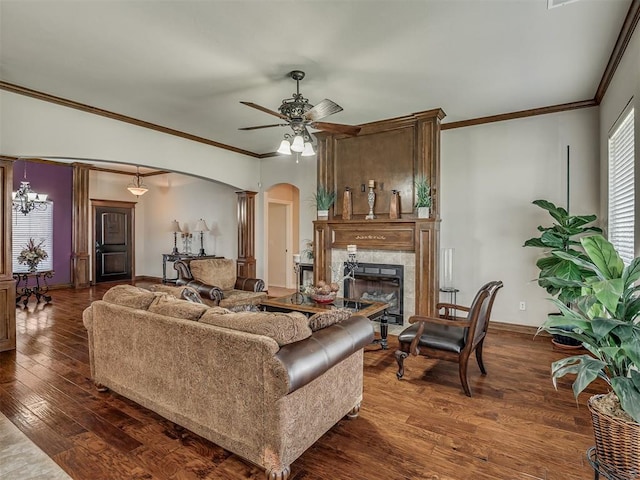 2825 SE 5th St, Moore, OK 73160 - living room with arched walkways, a fireplace, dark wood finished floors, a ceiling fan, and crown molding