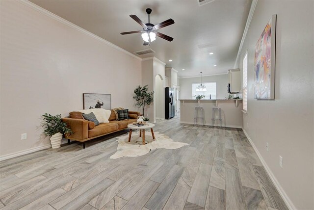 8340 NW 137th St, Oklahoma City, OK 73142 - living area featuring crown molding, ceiling fan, light wood-style flooring, recessed lighting, and a chandelier