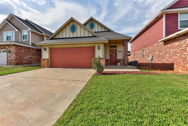 8340 NW 137th St, Oklahoma City, OK 73142 - view of front facade with concrete driveway, a front lawn, an attached garage, board and batten siding, and roof with shingles