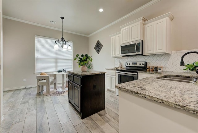 8340 NW 137th St, Oklahoma City, OK 73142 - kitchen featuring stainless steel appliances, a chandelier, light stone countertops, crown molding, and backsplash