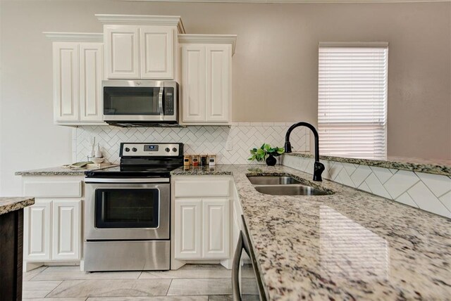 8340 NW 137th St, Oklahoma City, OK 73142 - kitchen with stainless steel appliances, light stone counters, backsplash, and white cabinets