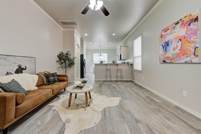 8340 NW 137th St, Oklahoma City, OK 73142 - living room with crown molding, a ceiling fan, light wood-style floors, recessed lighting, and a chandelier
