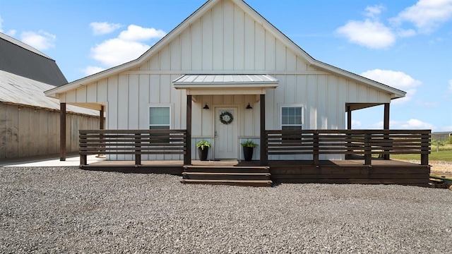 10506 W Smith Rd, El Reno, OK 73036 - view of front of home featuring board and batten siding, a standing seam roof, a wooden deck, and a metal roof