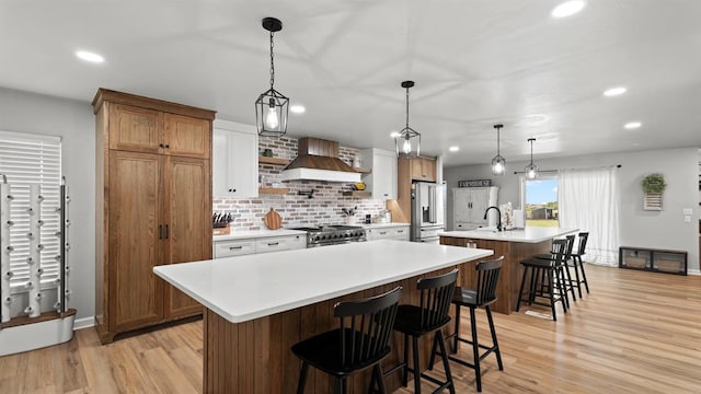 10506 W Smith Rd, El Reno, OK 73036 - kitchen with a center island with sink, premium appliances, premium range hood, recessed lighting, and light countertops