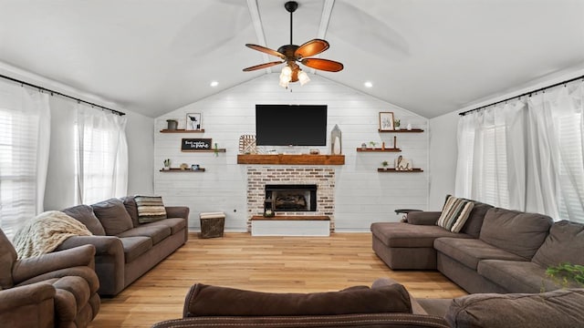 10506 W Smith Rd, El Reno, OK 73036 - living room with a ceiling fan, vaulted ceiling, light wood finished floors, wood walls, and a brick fireplace
