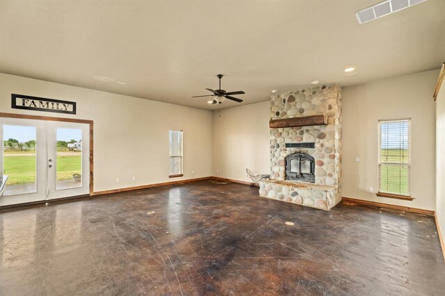3895 NE Arrowhead Rd, Piedmont, OK 73078 - unfurnished living room featuring a fireplace, a ceiling fan, concrete flooring, and french doors