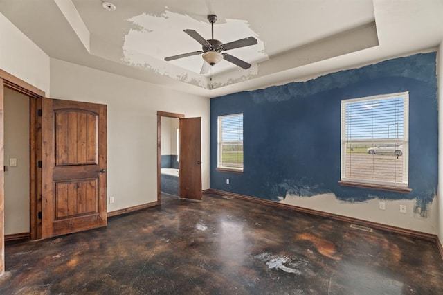 3895 NE Arrowhead Rd, Piedmont, OK 73078 - unfurnished bedroom with a raised ceiling, concrete flooring, and a ceiling fan