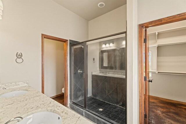 3895 NE Arrowhead Rd, Piedmont, OK 73078 - bathroom featuring a shower stall, double vanity, and a walk in closet