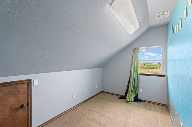 3895 NE Arrowhead Rd, Piedmont, OK 73078 - bonus room with lofted ceiling, carpet floors, and a textured ceiling