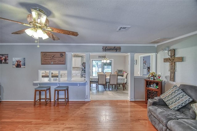 13086 240th, Blanchard, OK 73010 - living area with light wood-type flooring, ceiling fan, a textured ceiling, and crown molding
