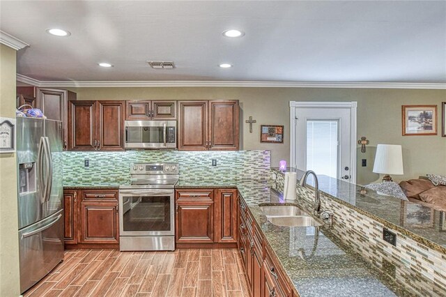 13086 240th, Blanchard, OK 73010 - kitchen featuring appliances with stainless steel finishes, decorative backsplash, crown molding, dark stone countertops, and brown cabinets