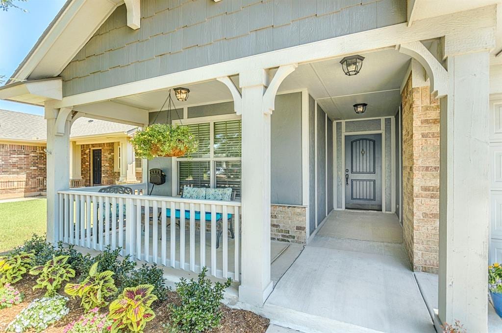 18217 Agua Dr, Edmond, OK 73012 - view of exterior entry featuring a porch