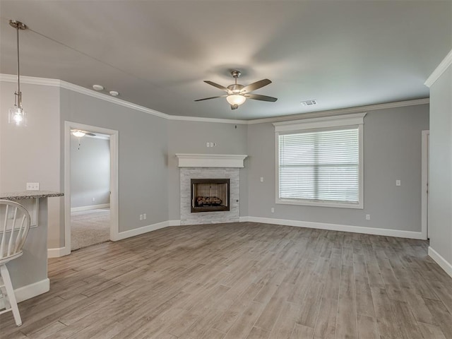3713 Andrew Ct, Norman, OK 73072 - unfurnished living room with a ceiling fan, light wood-type flooring, baseboards, crown molding, and a stone fireplace