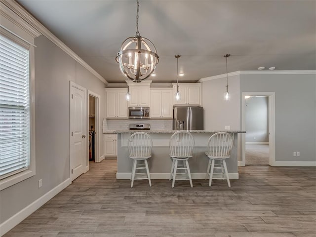 3713 Andrew Ct, Norman, OK 73072 - kitchen featuring appliances with stainless steel finishes, ornamental molding, a chandelier, tasteful backsplash, and a breakfast bar