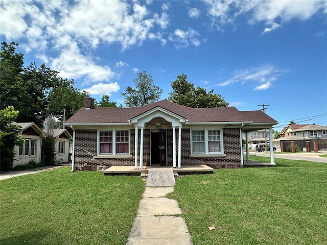 2001 NW 18th St, Oklahoma City, OK 73106 - view of front of house featuring a chimney, brick siding, a front yard, and a shingled roof
