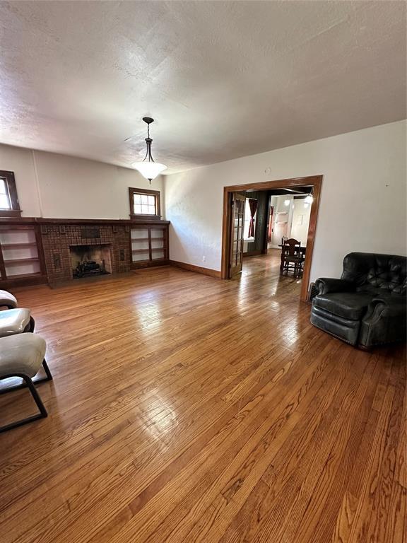 2001 NW 18th St, Oklahoma City, OK 73106 - living room featuring wood finished floors, a fireplace, and a textured ceiling