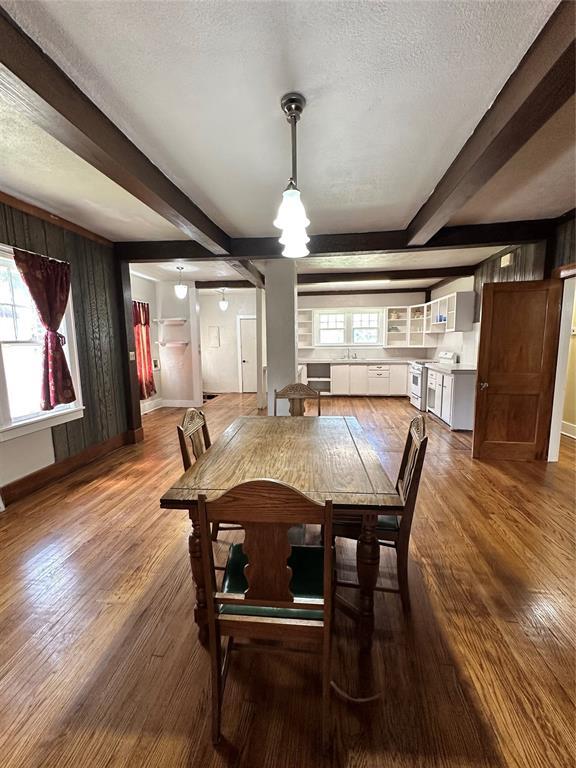 2001 NW 18th St, Oklahoma City, OK 73106 - dining area featuring beamed ceiling, wood finished floors, a textured ceiling, and a chandelier