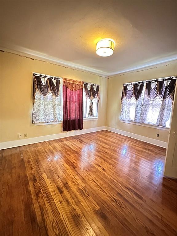 2001 NW 18th St, Oklahoma City, OK 73106 - empty room featuring healthy amount of natural light and wood finished floors