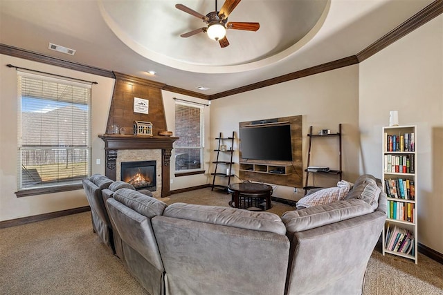 309 Turnberry Dr, Norman, OK 73069 - living room featuring carpet, a ceiling fan, baseboards, a raised ceiling, and ornamental molding