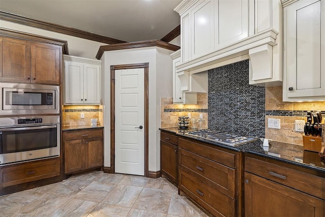 309 Turnberry Dr, Norman, OK 73069 - kitchen with appliances with stainless steel finishes, crown molding, decorative backsplash, and dark stone countertops