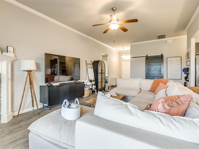 3911 Wiltshire Dr, Norman, OK 73026 - living room with ceiling fan, light wood-style floors, ornamental molding, baseboards, and a barn door