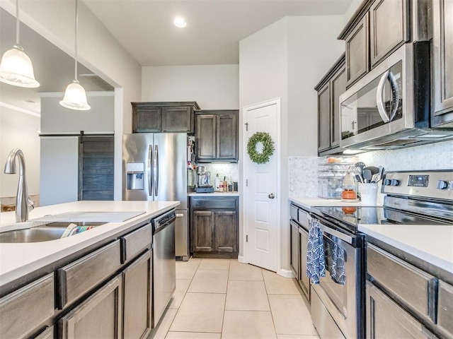 3911 Wiltshire Dr, Norman, OK 73026 - kitchen featuring appliances with stainless steel finishes, a sink, decorative light fixtures, tasteful backsplash, and light tile patterned floors