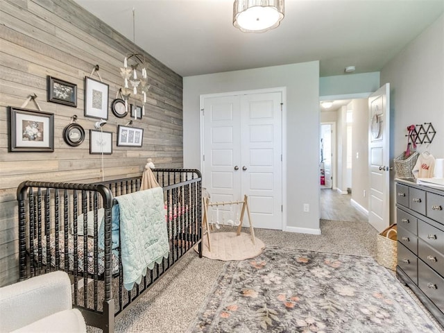 3911 Wiltshire Dr, Norman, OK 73026 - bedroom featuring wood walls, an accent wall, baseboards, a closet, and carpet