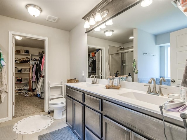 3911 Wiltshire Dr, Norman, OK 73026 - full bath with double vanity, a walk in closet, a stall shower, and toilet